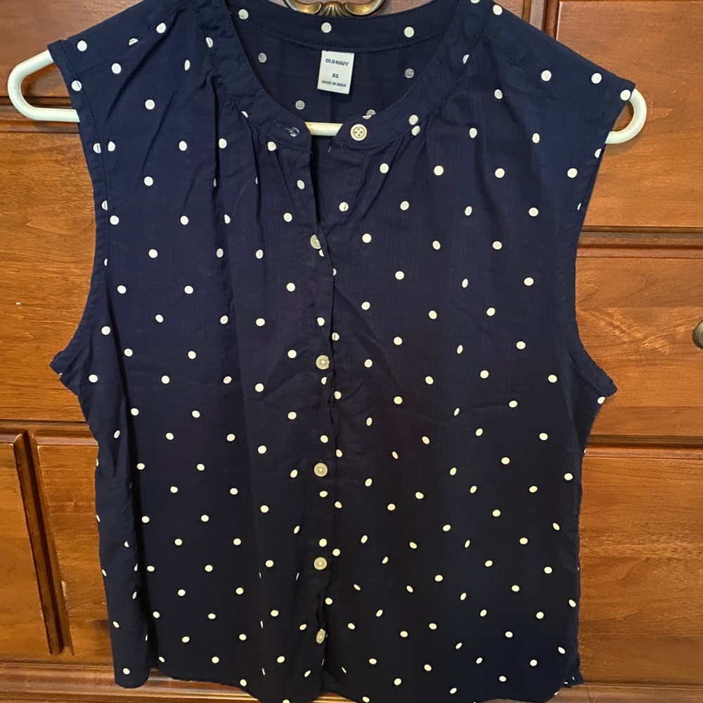 Sleeveless navy blouse with white polka dots